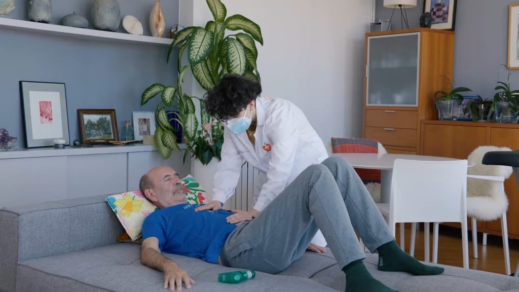 Fisioterapeuta aplicando respiración diafragmática en anciano